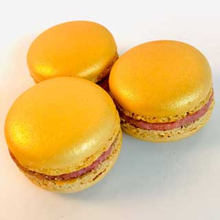 gouden macaron met een ganache van witte chocolade en aardbei